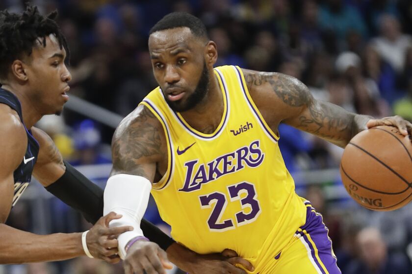 Los Angeles Lakers' LeBron James (23) drives around Orlando Magic's Wes Iwundu, left, during the first half of an NBA basketball game, Wednesday, Dec. 11, 2019, in Orlando, Fla. (AP Photo/John Raoux)