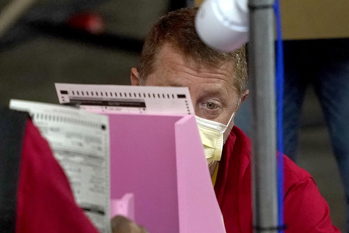 Worker examining election ballot in Phoenix