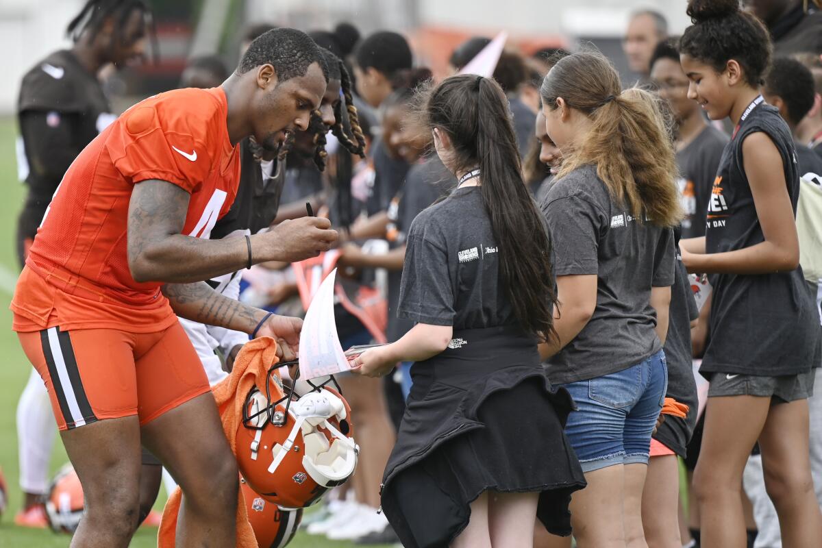 El quarterback de los Browns de Cleveland, Deshaun Watson, firma autógrafos al término de una sesión 