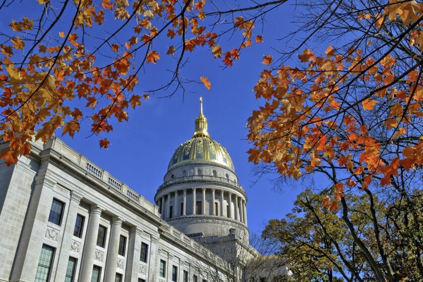 FILE - This Nov. 3, 2014 file photo shows the West Virginia Capitol with its dome framed by turning sugar maples leaves in Charleston, W.Va. West Virginia's unemployed workers will need to do more to prove they are searching for jobs to collect state benefits under a new law that will take effect next year. (Tom Hindman/Charleston Gazette-Mail via AP, File)