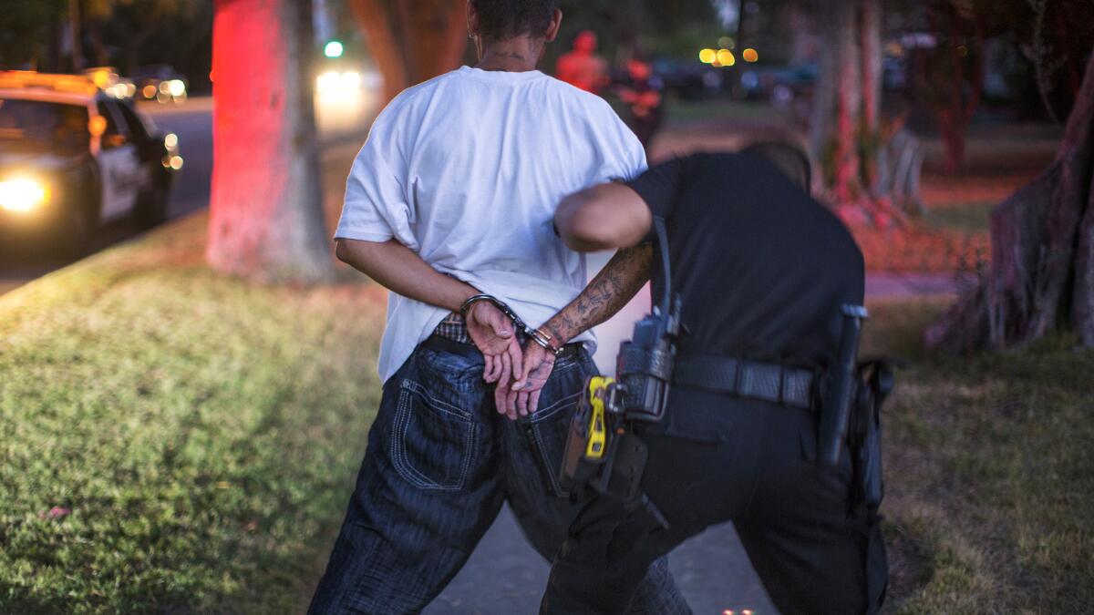 A San Bernardino police officer searches a suspect.