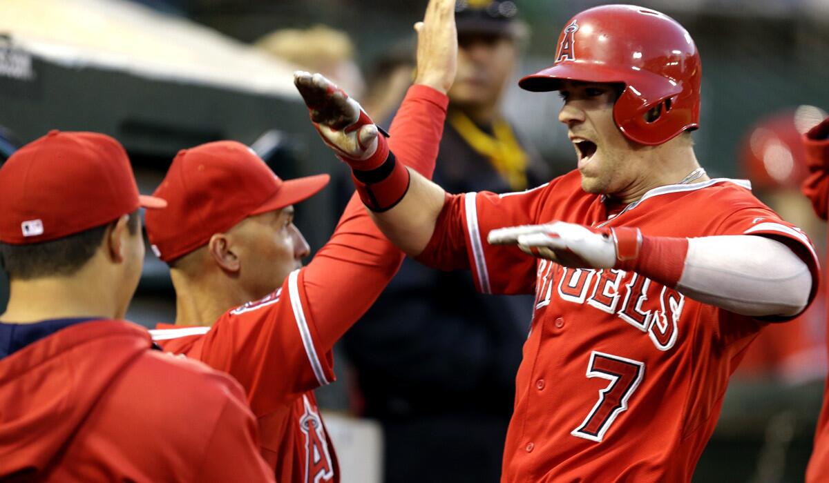 Angels center fielder Collin Cowgill (7) is congratulated in the dugout after hitting a three-run home run against the Athletics on Saturday night in Oakland.
