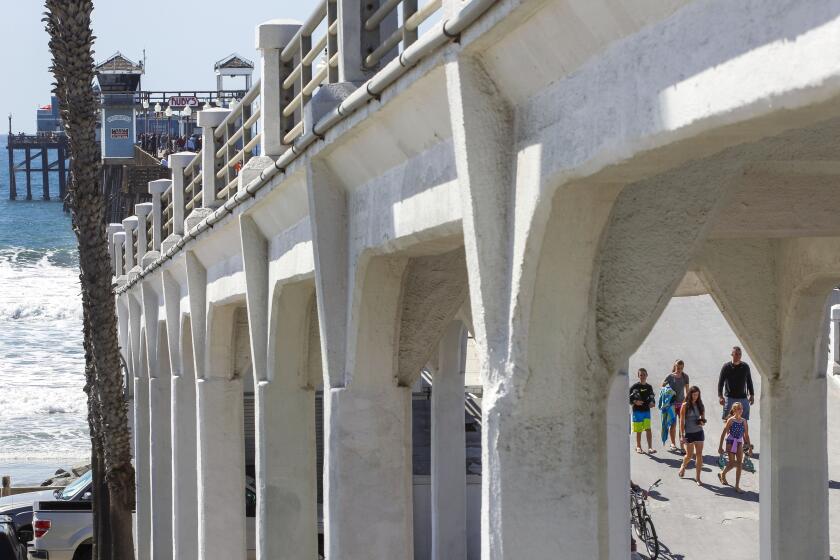 OCEANSIDE, October 9, 2018 | With the concrete bridge that connects to the Oceanside Pier in the foreground, people walk down the ramp to The Strand in Oceanside on Tuesday. | Photo by Hayne Palmour IV/San Diego Union-Tribune/Mandatory Credit: HAYNE PALMOUR IV/SAN DIEGO UNION-TRIBUNE/ZUMA PRESS San Diego Union-Tribune Photo by Hayne Palmour IV copyright 2018