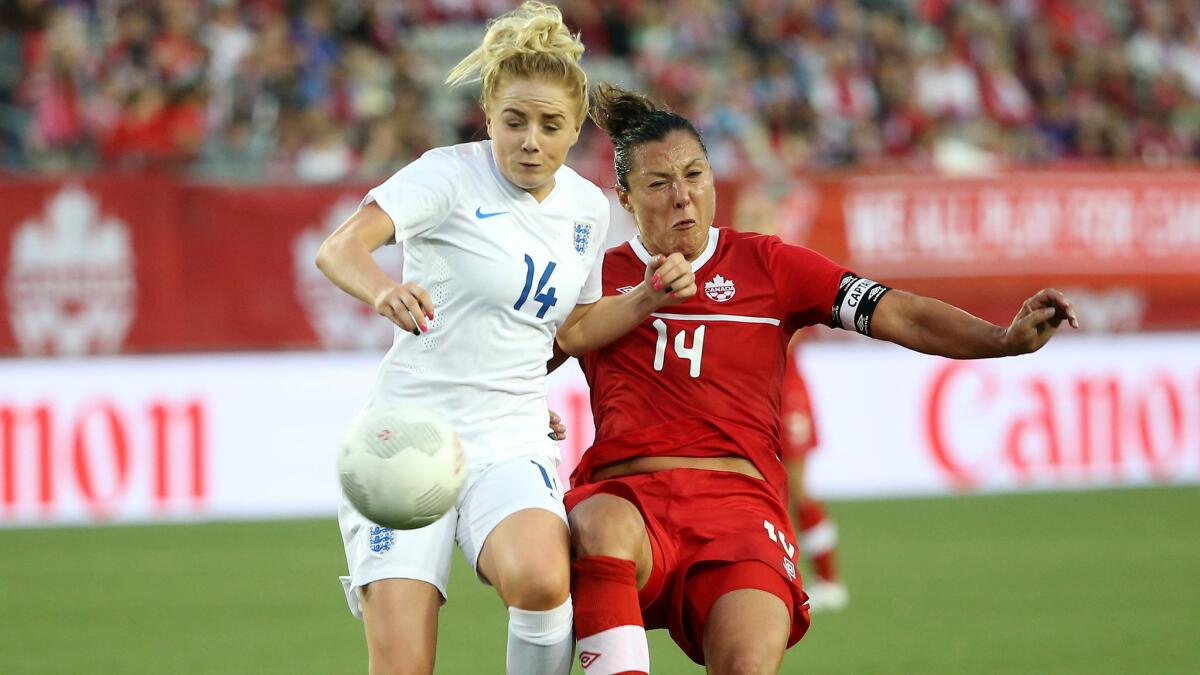 England's Alex Greenwood, left, and Canada's Melissa Tancredi battle for possession of the ball during an exhibition game on May 28 in Ontario, Canada.