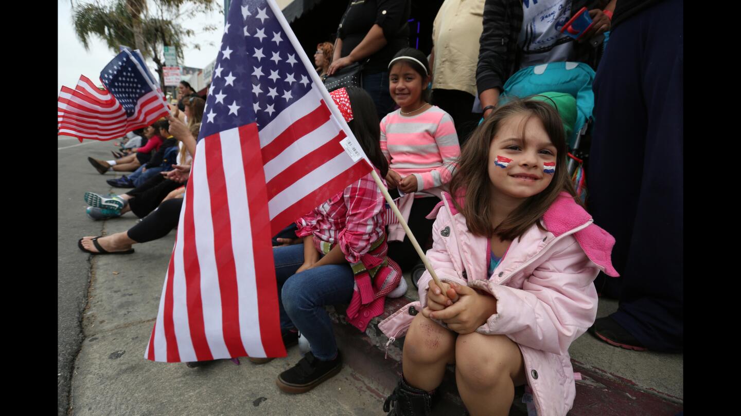 Gabriella Miller, 4, holding flag, attends the 26th annual Canoga Park Memorial Day Parade down Sherman Way on Monday.