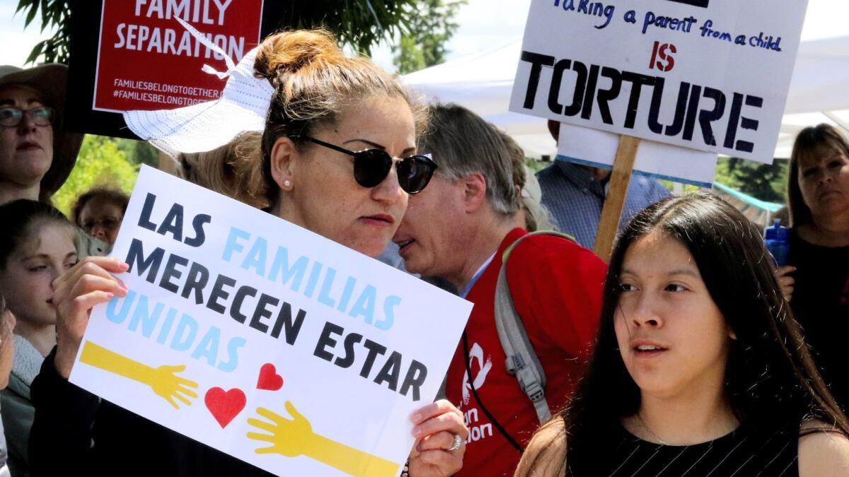 Demonstrators outside the Federal Detention Center in SeaTac, Wash., on Saturday, protest the government policy of separating asylum-seeking parents from their children. The sign in Spanish reads, "Families deserve to be together."