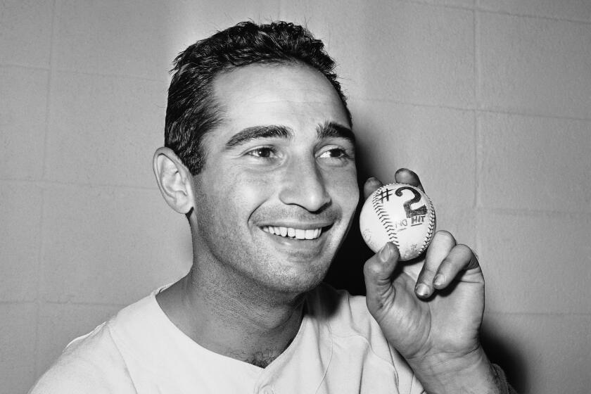 Sandy Koufax of the Los Angeles Dodgers smiles as he holds a baseball on May, 12, 1963 symbolizing his second no-hitter in less than a year. He pitched his first no-hitter against the New York Mets on June 30, 1962. The 27-year-old left-hander barely missed a perfect game, retiring 22 men until he walked Ed Bailey in the eight and Willie McCovey (both of them San Francisco Giants) in the ninth. Dodgers won the ball game 8-0. (AP Photo/Harold Filan