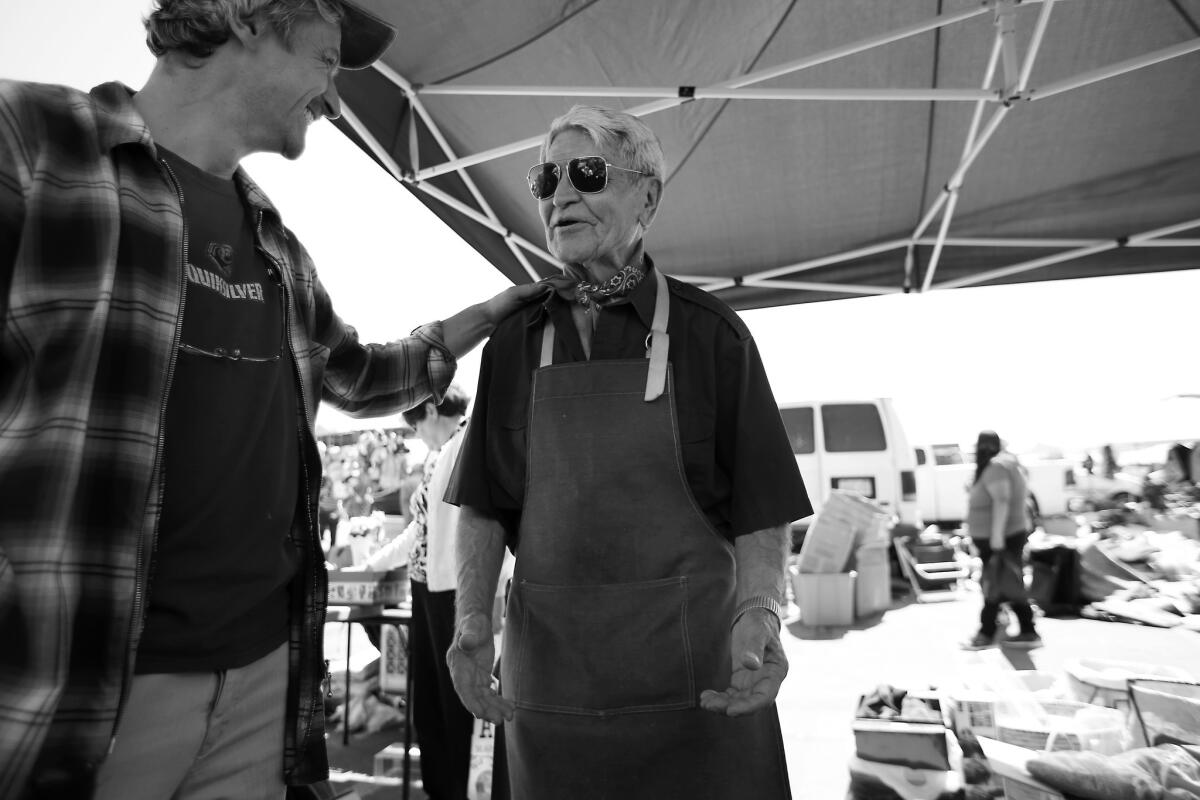 Jozsi Baky, left, helps Steve Hideg at the Alpine Village Swap Meet in Torrance to sell some of his belongings for food and medicine.