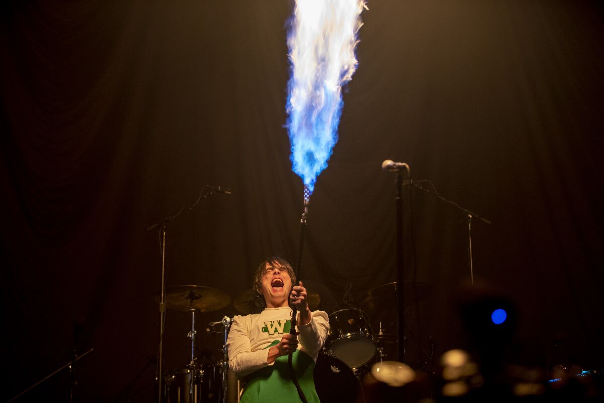 A rock singer fires a flamethrower on stage