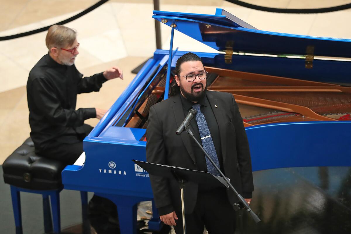 Pianist Severin Behnin and tenor vocalist Abraham Cervantes from Pacific Chorale perform at South Coast Plaza on Monday.
