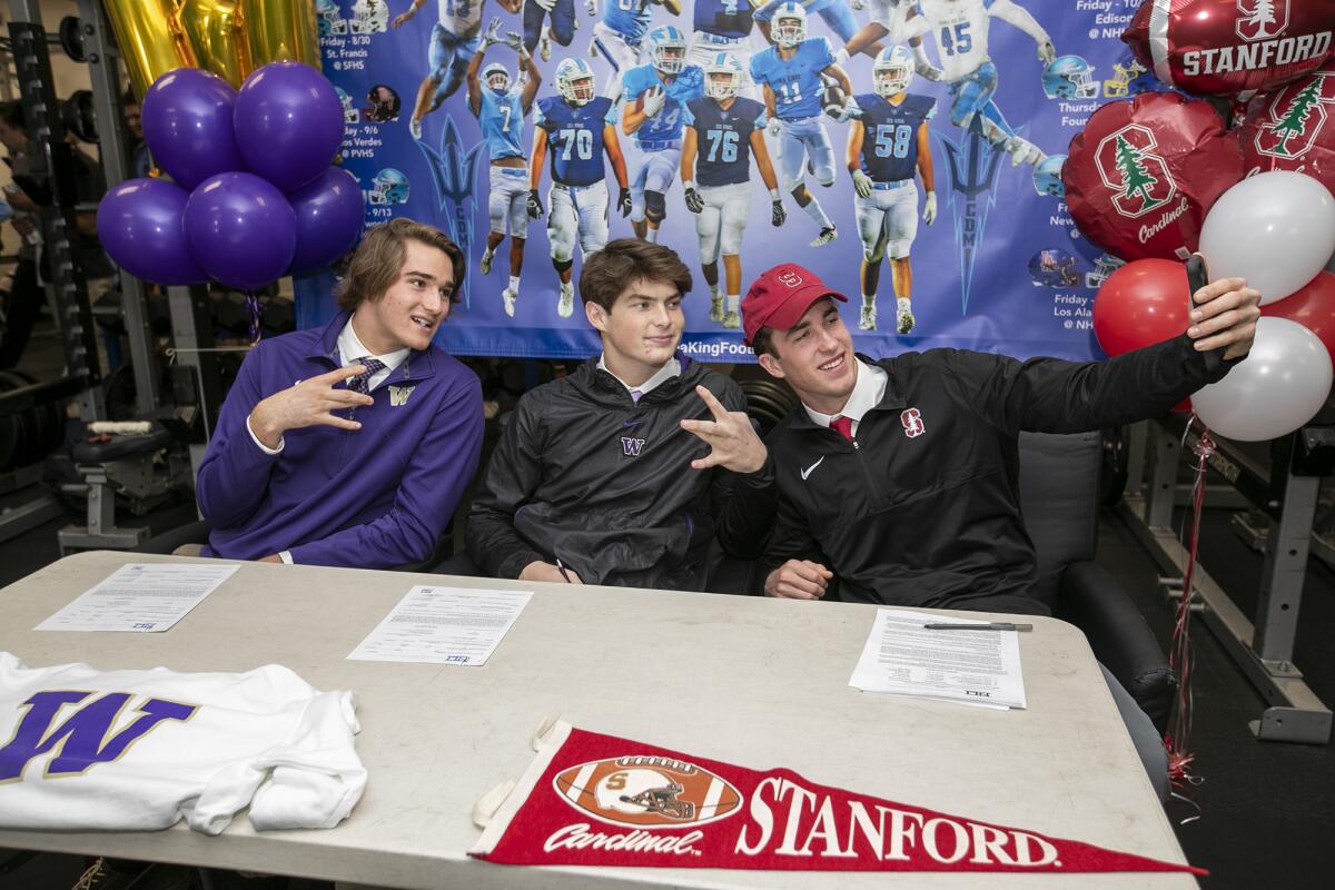 Corona del Mar's John Humphreys, right, takes a selfie with Ethan Garbers, center and Mark Redman as the three sign their national letters of intent on Wednesday in Newport Beach.