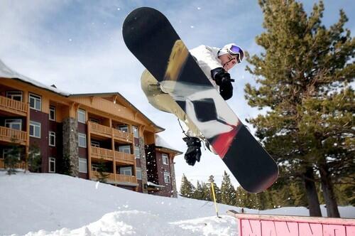 A snowboarder flies through the air in front of the Sunstone cono units in Mammoth Mountain.