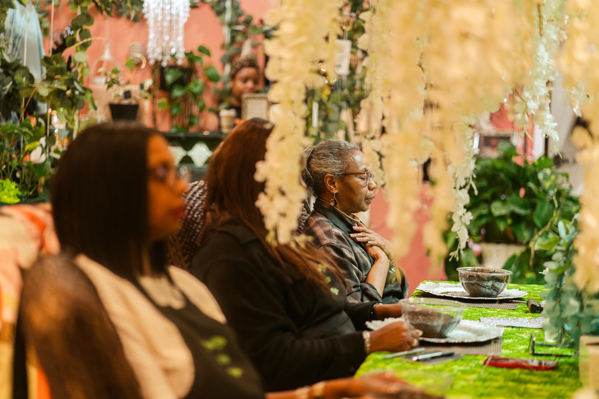 Several women at a table taking part in a soil meditation experience