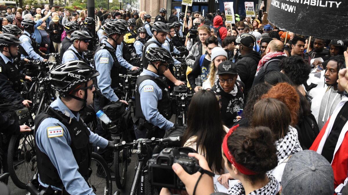 Protesters stand near police in Chicago after a jury convicted white police Officer Jason Van Dyke of second-degree murder in the 2014 shooting of black teen Laquan McDonald. Video released Tuesday shows a Chicago police officer shooting an unarmed autistic black man in 2017.