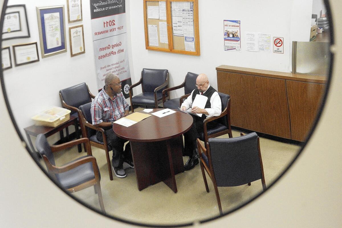 Senior paralegal John Garbin, right, helps Winfred White at the Los Angeles County public defender’s office.
