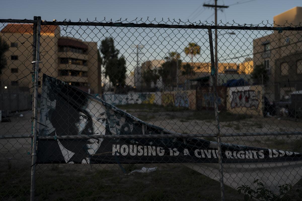 A banner depicting Martin Luther King Jr. hangs off a fence on Skid Row