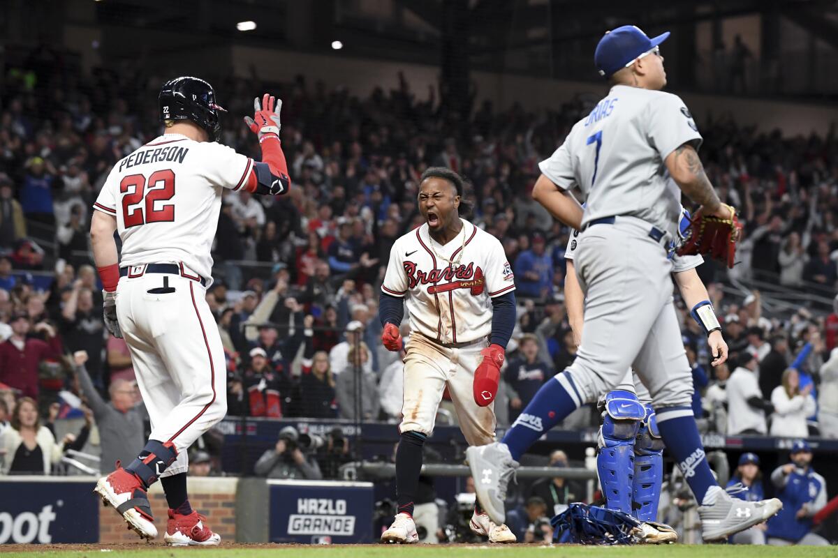 Atlanta's Eddie Rosario celebrates after scoring off a single by Ozzie Albies during the eighth inning.