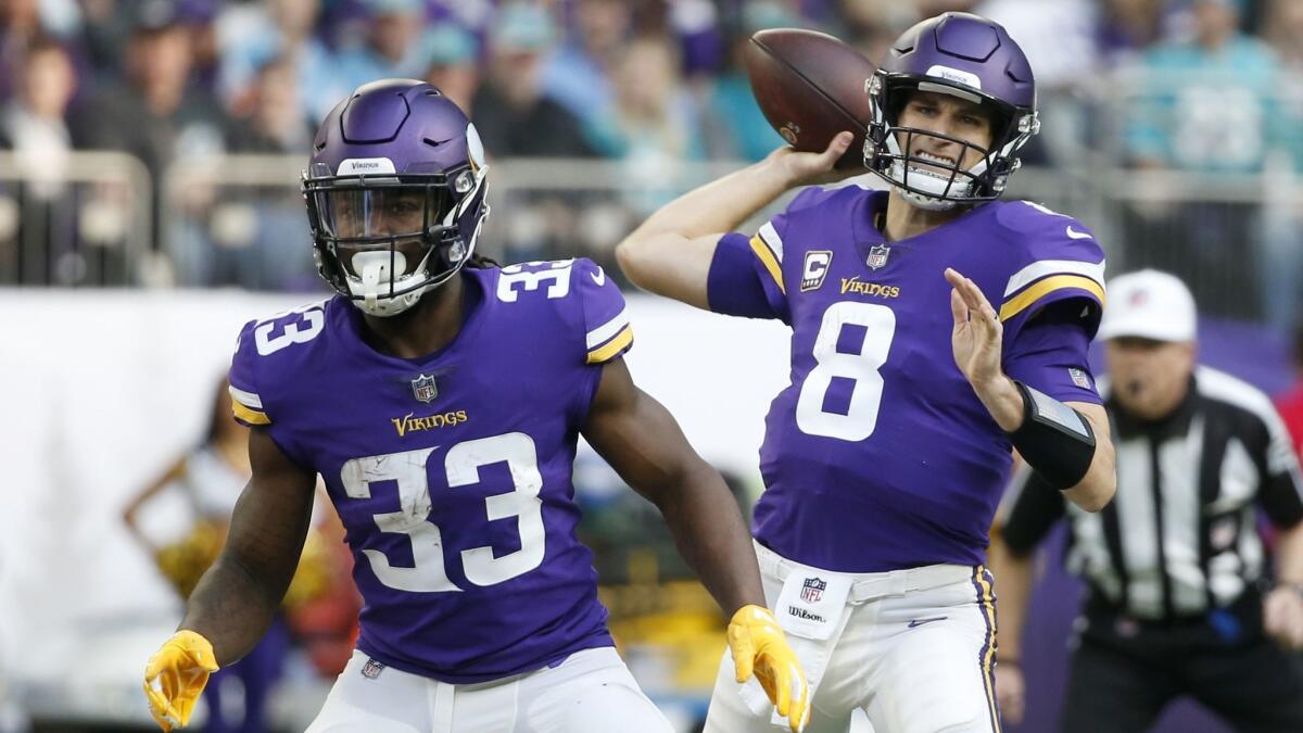Minnesota Vikings quarterback Kirk Cousins (8) throws a pass as teammate Dalvin Cook (33) blocks during the first half against the Miami Dolphins on Dec. 16, 2018, in Minneapolis.