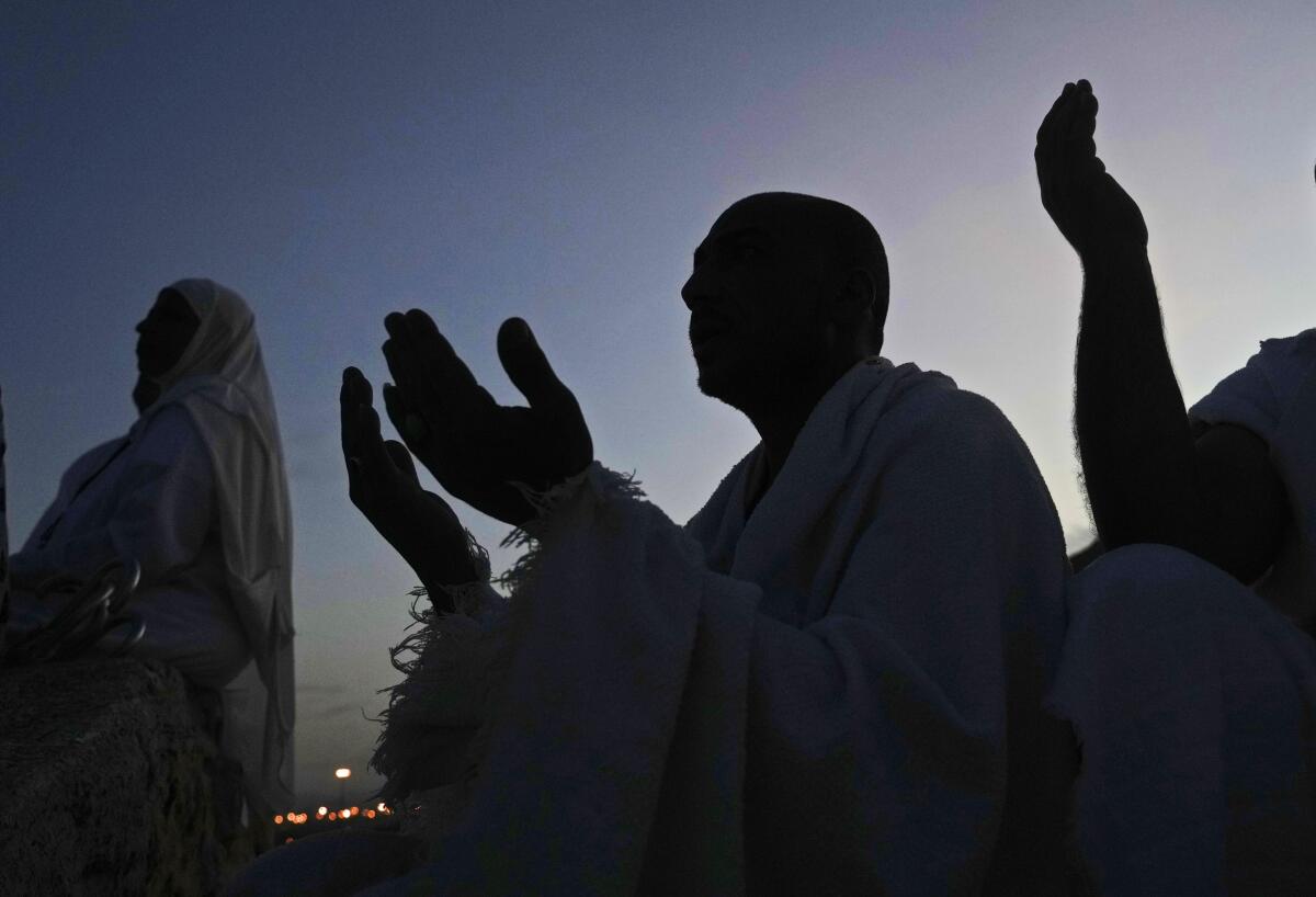 Muslim pilgrims pray on top of the rocky hill known as the Mountain of Mercy, on the Plain of Arafat, during the annual hajj pilgrimage, near the holy city of Mecca, Saudi Arabia, Friday, July 8, 2022. (AP Photo/Amr Nabil)