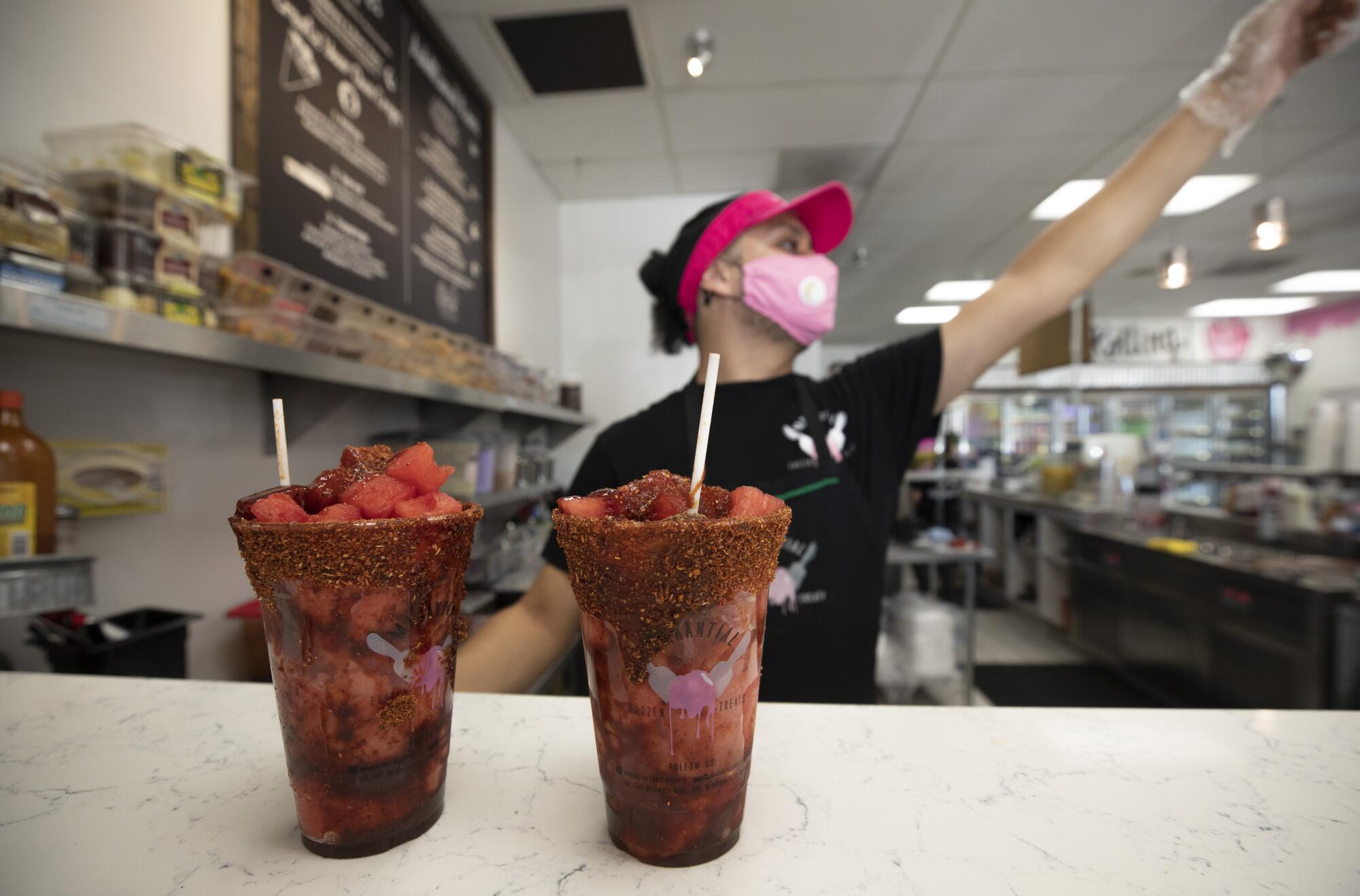 Acting manager Jesse Mercado signals that orders are ready at Manantial Frozen Treats in Palmdale.