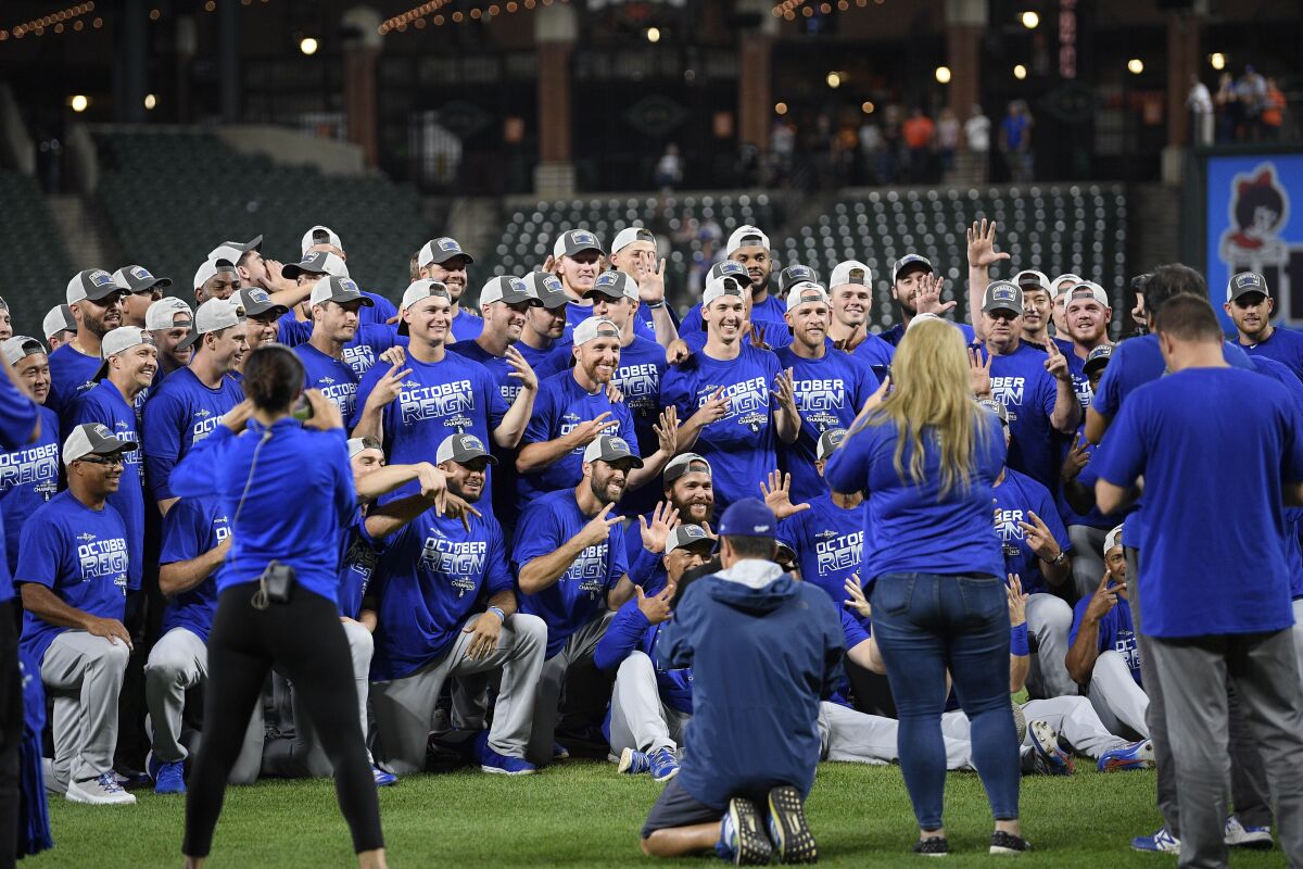 Members of the Dodgers pose on the field after winning Tuesday.