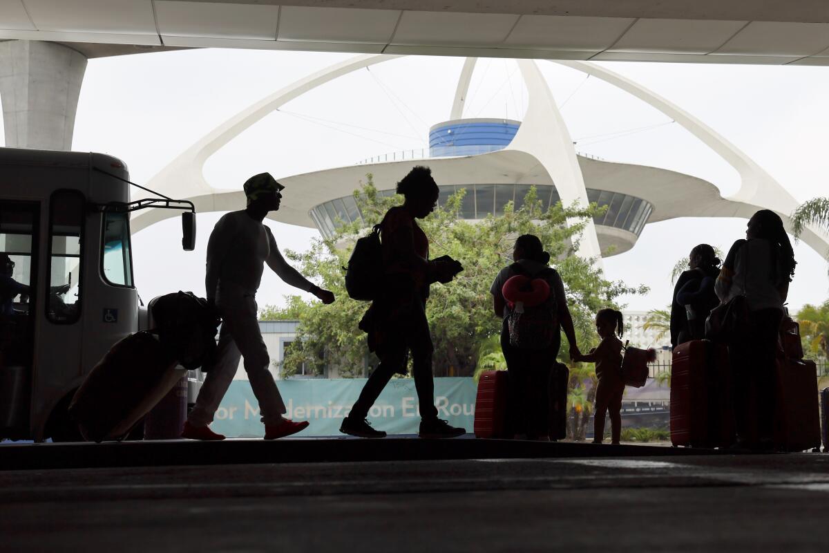 Pedestrians are silhouetted against a futuristic building.