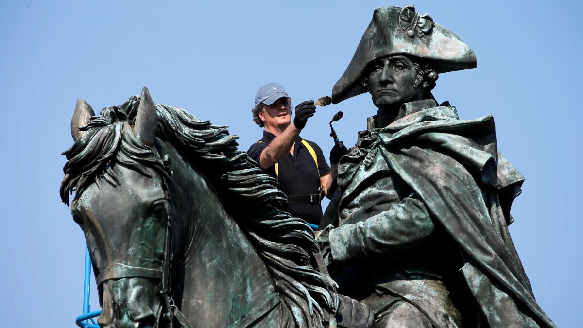 Douglas Martenson applies a patina to a bronze statue of George Washington near the Philadelphia Museum of Art on May 25.