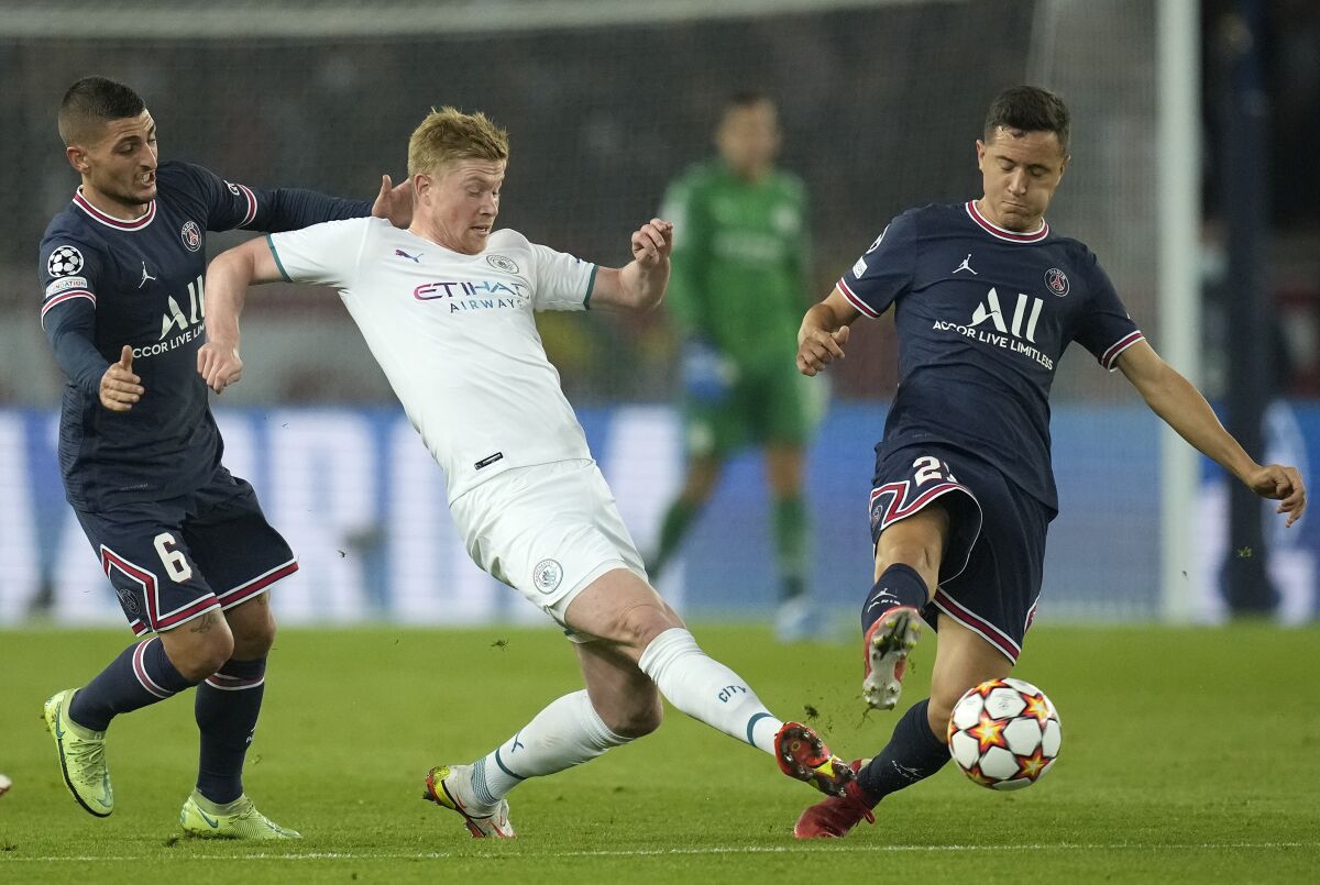 PSG's Marco Verratti, left, and PSG's Ander Herrera challenge Manchester City's Kevin De Bruyne during the Champions League Group A soccer match between Paris Saint-Germain and Manchester City at the Parc des Princes in Paris, Tuesday, Sept. 28, 2021. (AP Photo/Christophe Ena)