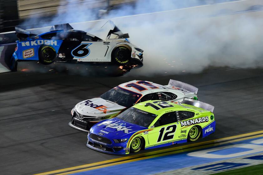 DAYTONA BEACH, FLORIDA - FEBRUARY 17: Denny Hamlin, driver of the #11 FedEx Express Toyota, and Ryan Blaney, driver of the #12 Menards/Peak Ford, race to the finish as Ryan Newman, driver of the #6 Koch Industries Ford, wrecks on the last lap of the NASCAR Cup Series 62nd Annual Daytona 500 at Daytona International Speedway on February 17, 2020 in Daytona Beach, Florida. (Photo by Jared C. Tilton/Getty Images)