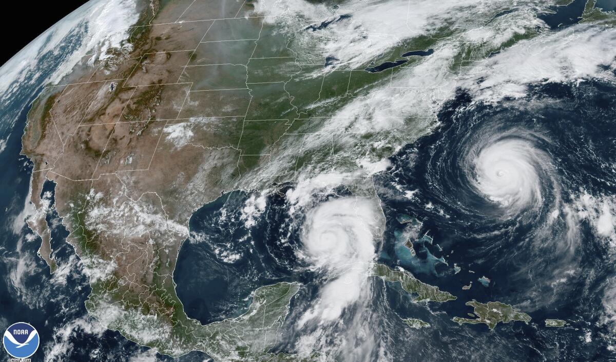 A satellite map shows one hurricane approaching Florida's Gulf Coast and another along the East Coast of the United States.