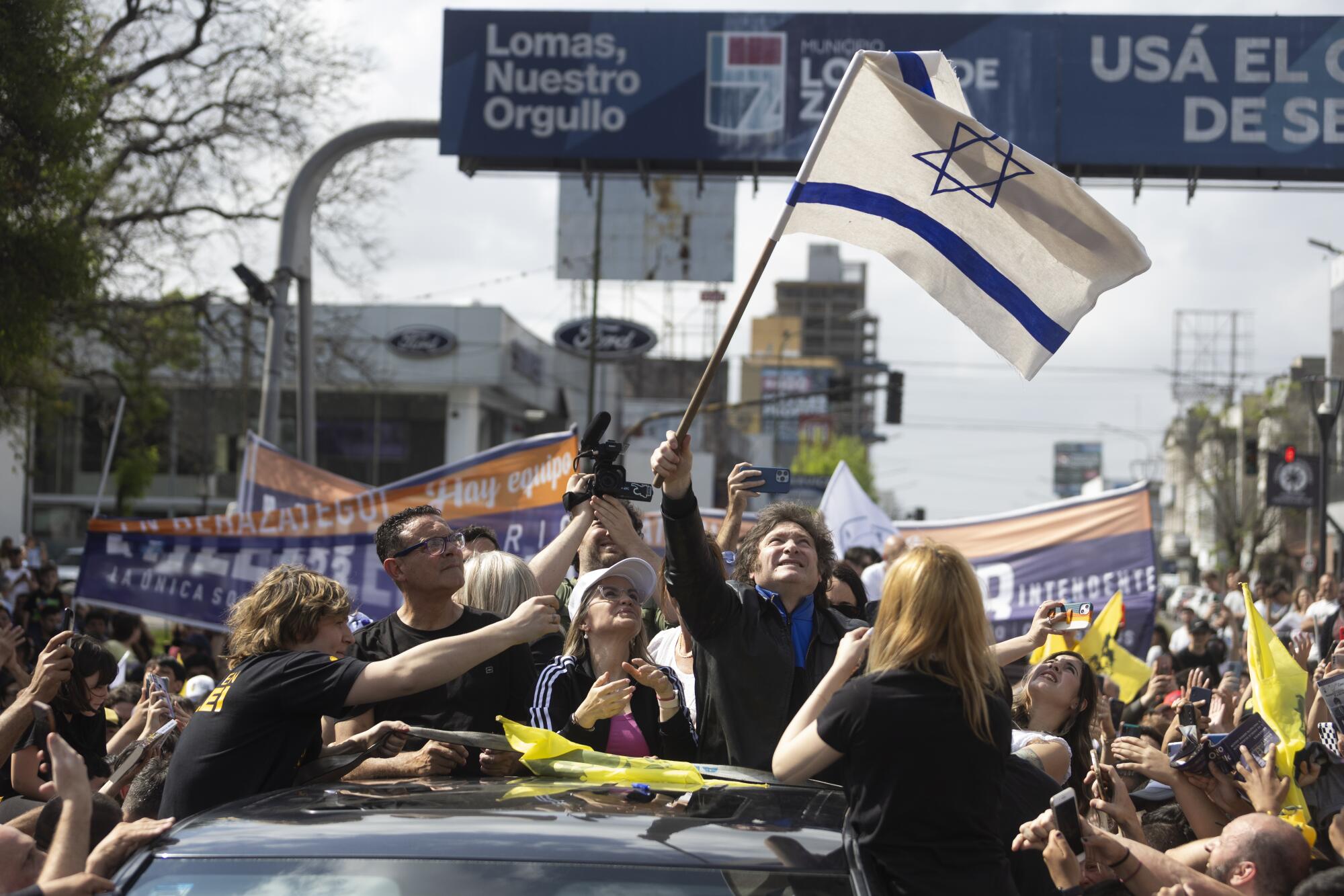 Javier Milei waves an Israeli flag in a crowd