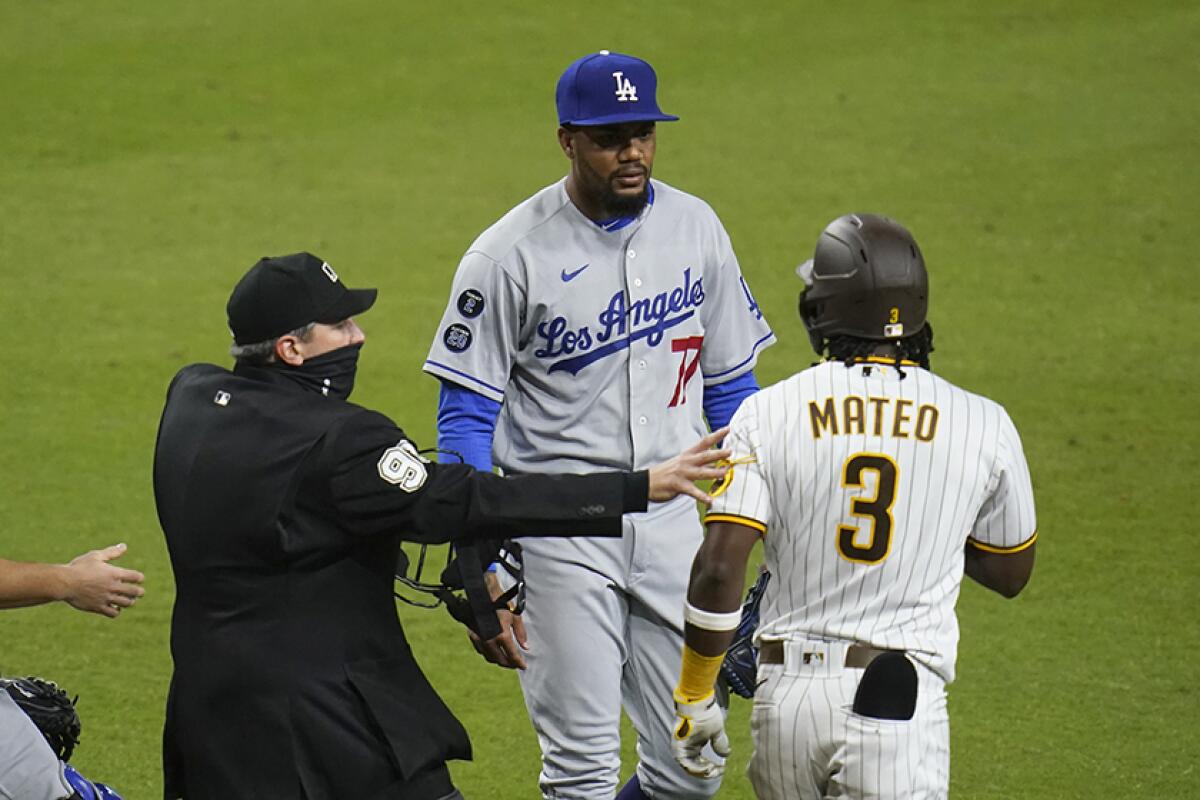 Dodgers pitcher Dennis Santana has words with the Padres' Jorge Mateo while an umpire has a hand on Mateo's arm.