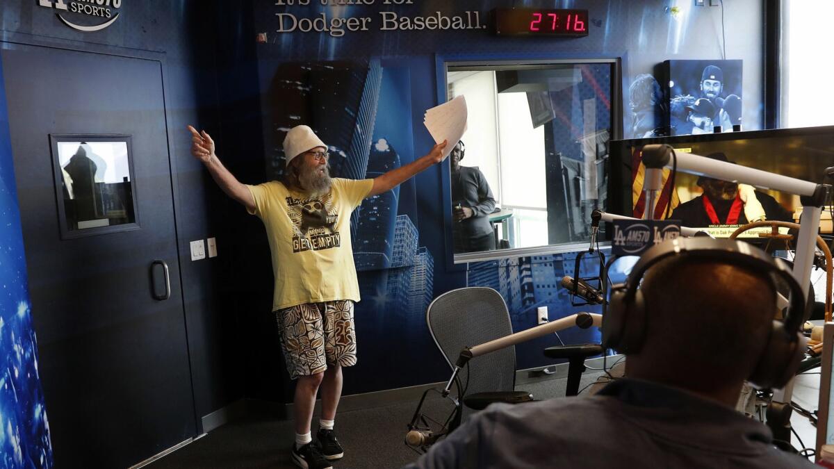 Radio sports announcer Vic "the Brick" Jacobs makes his entrance into the studio during the radio broadcast of the show, "Lunchtime with Roggin and Rodney" at iHeartMedia in Burbank.