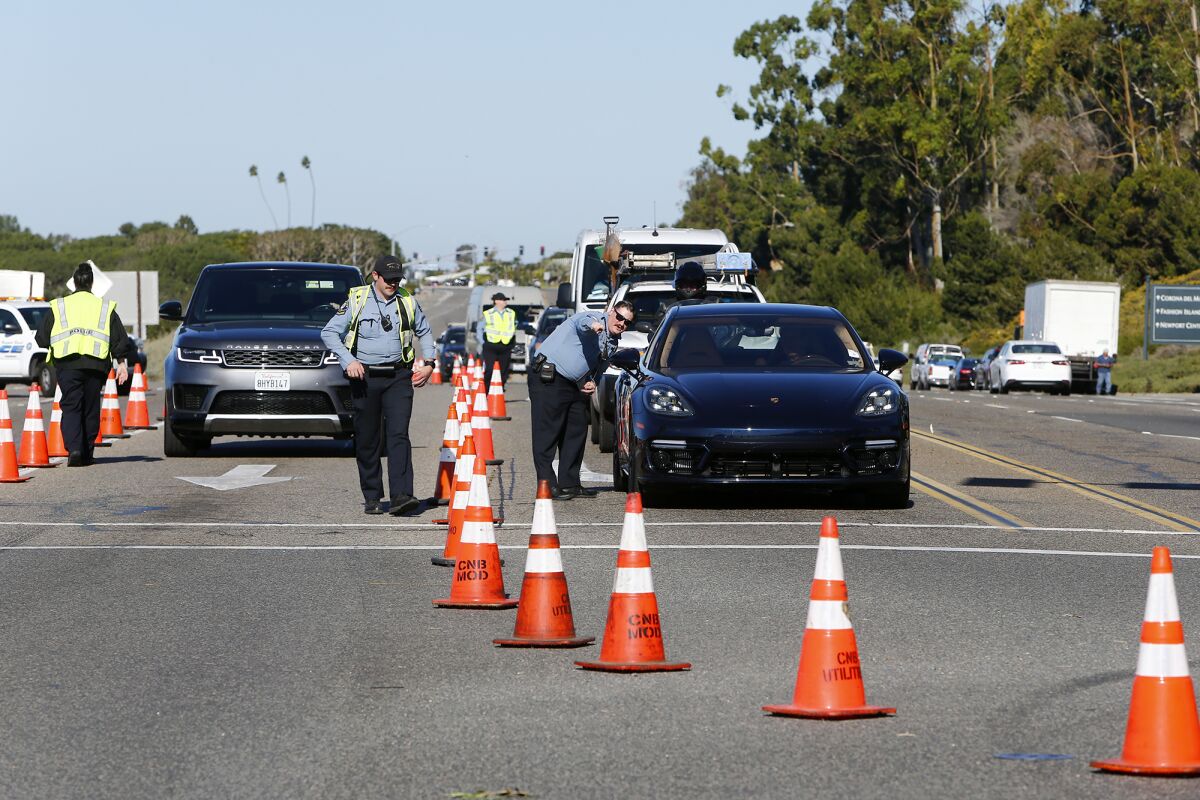 Newport Beach police officers direct traffic heading south along Pacific Coast Highway toward Laguna Beach Thursday morning.