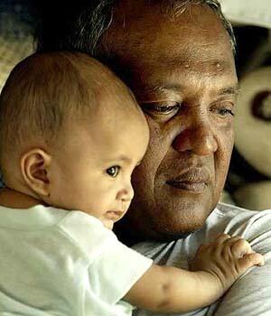 Amiruddin Azit holds his four-month-old son Abil. The Indonesian fish vendor lost two sons to the tsunami.