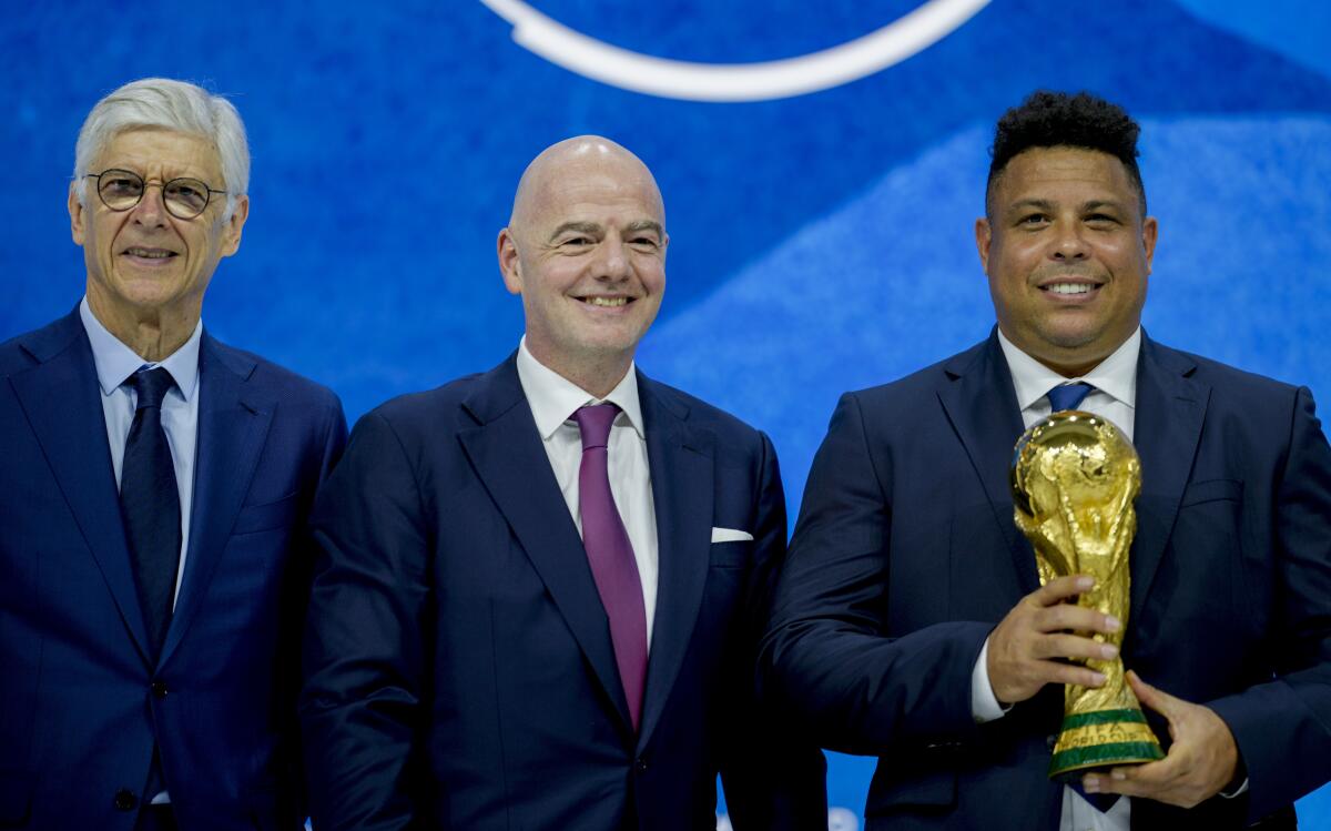 Fifa President Gianni Infantino, center, former Brazilian soccer player Ronaldo, right, and Swiss soccer coach Arsene Wenger stand together during the World Economic Forum in Davos, Switzerland, Monday, May 23, 2022. The annual meeting of the World Economic Forum is taking place in Davos from May 22 until May 26, 2022. (AP Photo/Markus Schreiber)