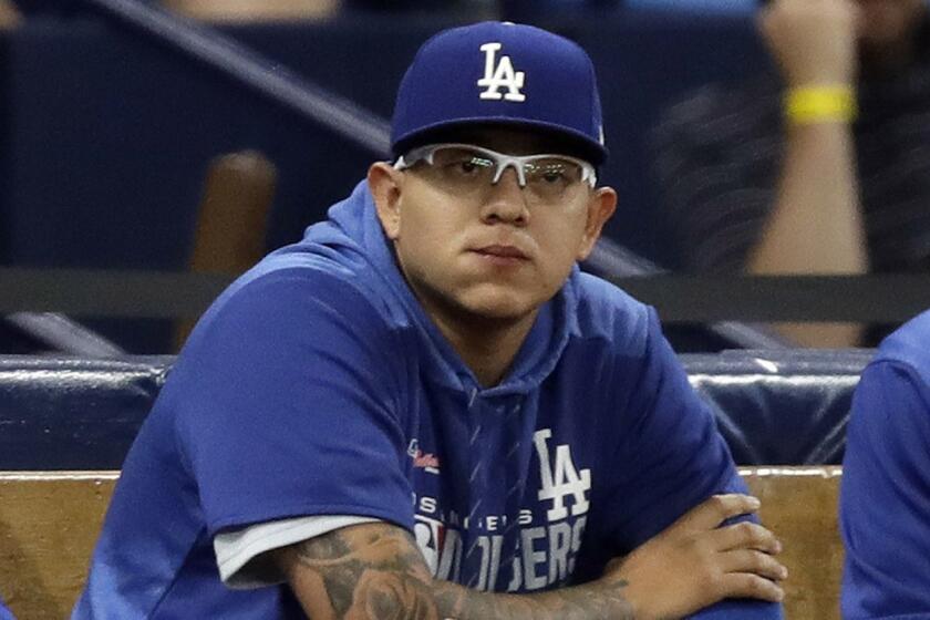 Los Angeles Dodgers pitcher Julio Urias sits in the bullpen during the second inning of the team's baseball game against the Tampa Bay Rays on Tuesday, May 21, 2019, in St. Petersburg, Fla. Urias was reinstated Tuesday from administrative leave by Major League Baseball. (AP Photo/Chris O'Meara)