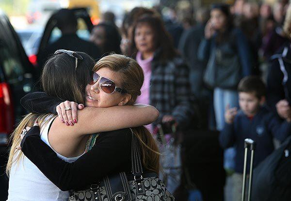 Marina del Rey residents Claudia Alvares, right, and Claudia Costa embrace at Terminal 5, where no long lines or obvious delays were evident.