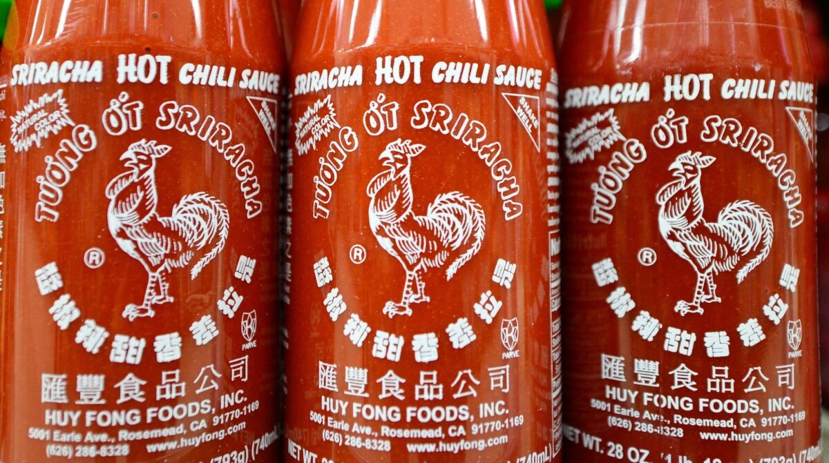 Bottles of Sriracha chili sauce on shelves inside a supermarket in Rosemead.