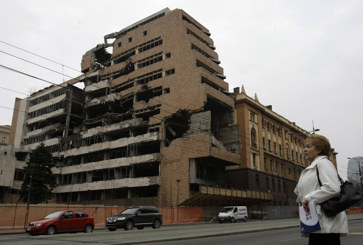 FILE - A woman walks in front of the destroyed former Serbian army headquarters in Belgrade, Serbia, on March 24, 2010. Well before Russian tanks and troops rolled into Ukraine, Vladimir Putin was using the bloody breakup of Yugoslavia in the 1990s to ostensibly offer justification for the invasion of a sovereign European country. The Russian president has been particularly focused on NATO’s bombardment of Serbia in 1999 and the West’s acceptance of Kosovo’s declaration of independence in 2008. He claims both created an illegal precedent that shattered international law and order, apparently giving him an excuse to invade Ukraine. (AP Photo/Darko Vojinovic, File)