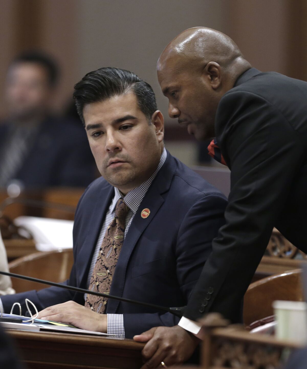 File photo of California Insurance Commissioner Ricardo Lara, seated. A consumer group called for a criminal probe into his fundraising practices.
