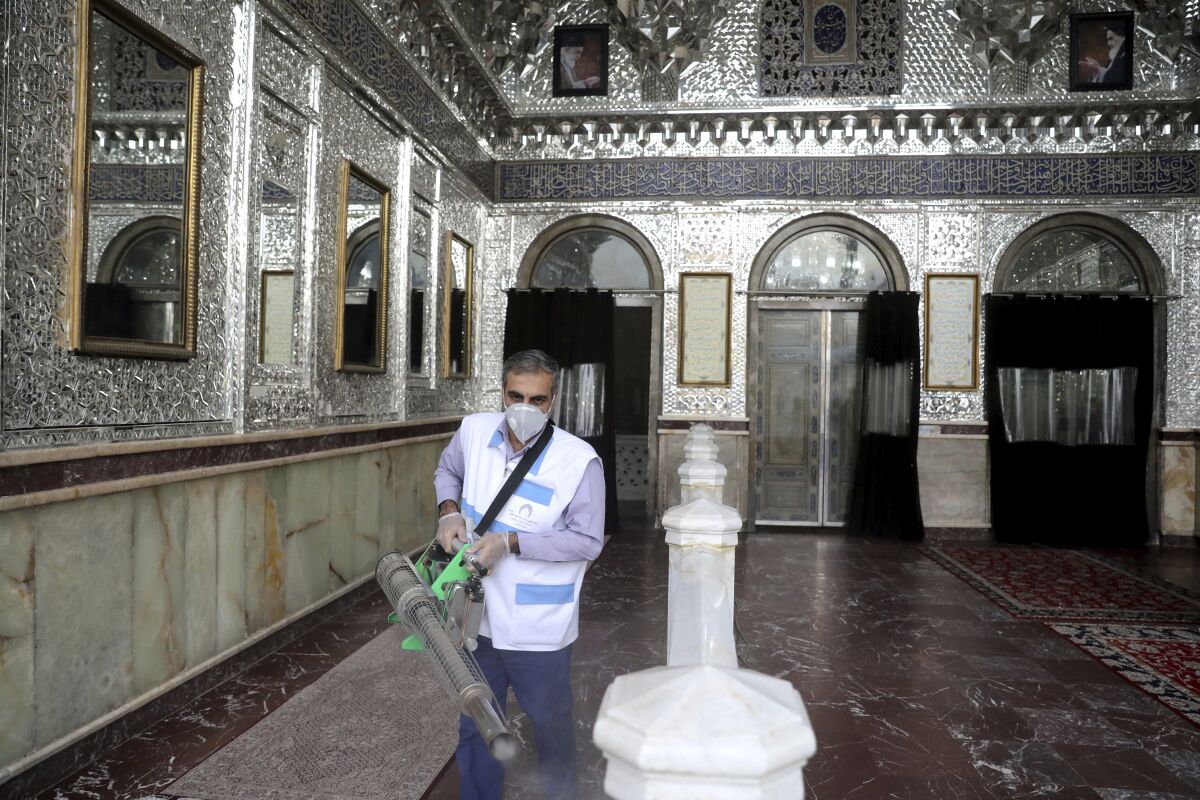 A man disinfects the shrine of the Shiite Saint Imam Abdulazim.