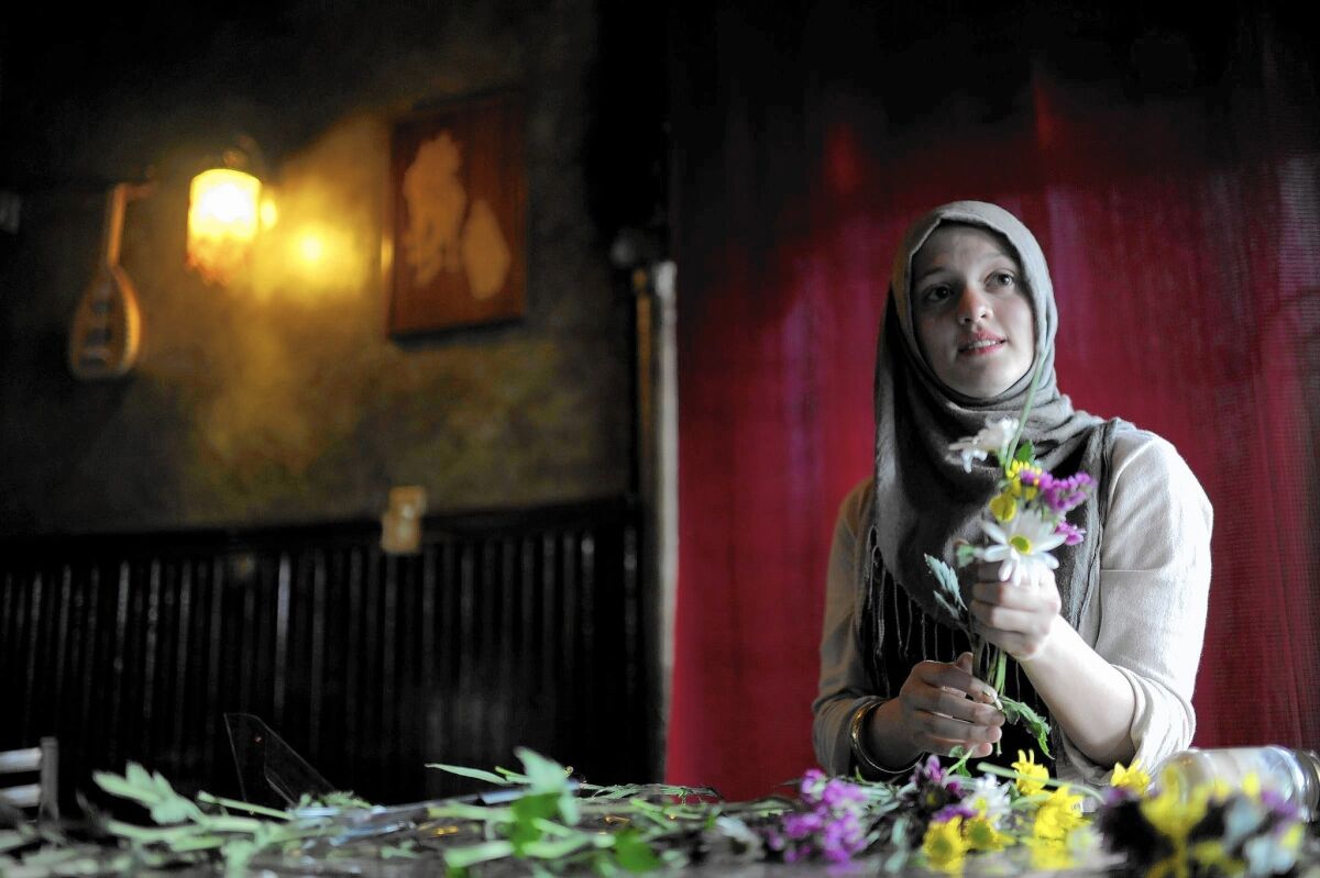 Waitress Amal Kassir prepares flowers for the tables at Damascus Grill in Littleton, Colo., on April 19, 2012.
