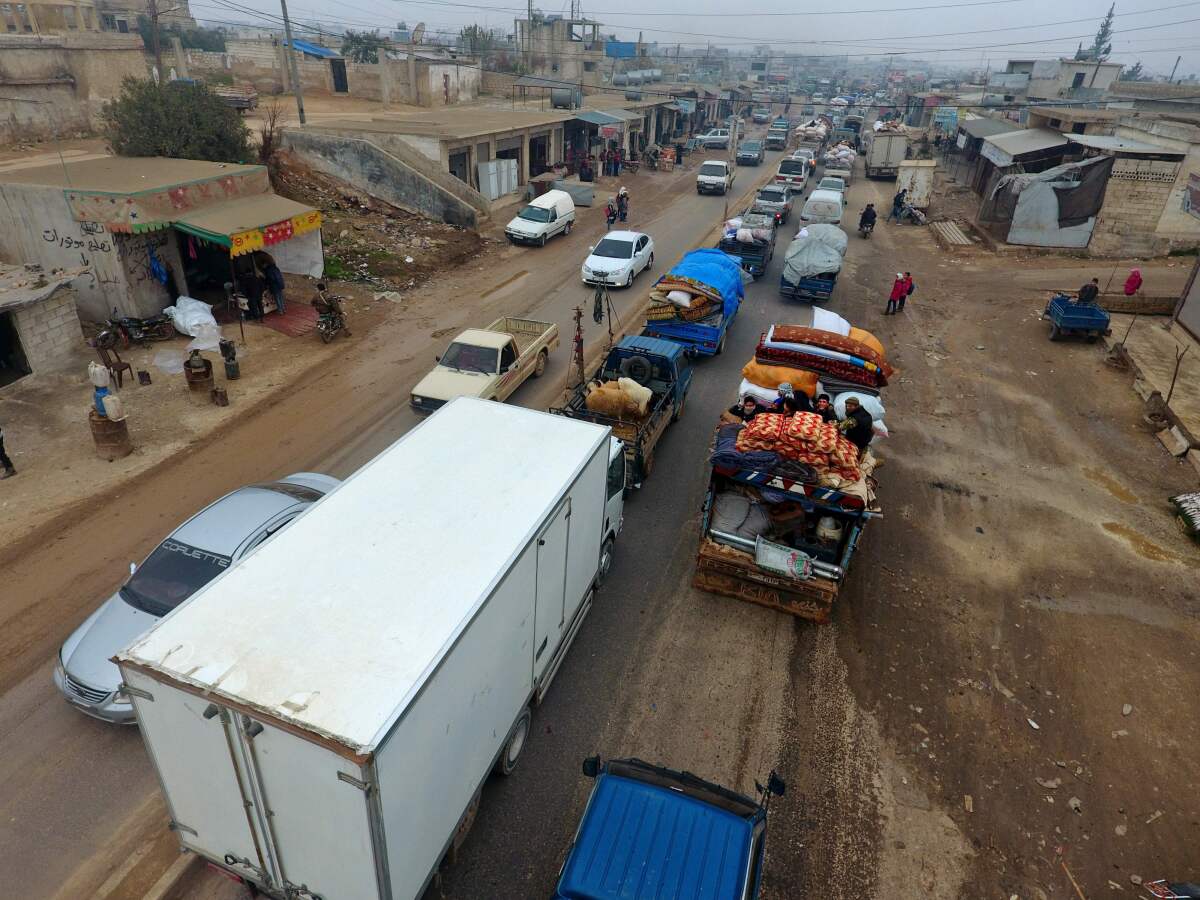 Syrian families drive through the village of Hazano, about 20 kilometers northwest of the city of Idlib, towards the Syrian-Turkish border as they flee from the assault led by government forces and their allies.