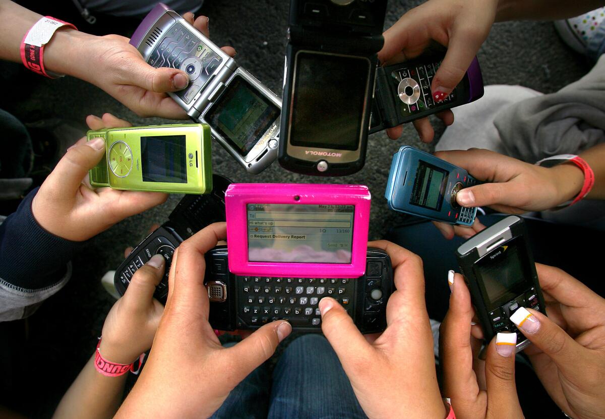 Granite Elementary School sixth-grade students hold up their cellphones in Sandy, Utah, in 2008. (AP Photo/Deseret News, Kristin Murphy)