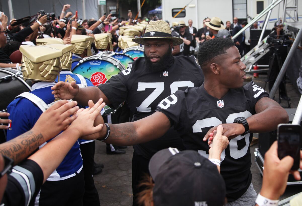 Oakland Raiders Justin Ellis, left, and T.J. Carrie greet fans during an event at Azteca Stadium in Mexico City on April 30.