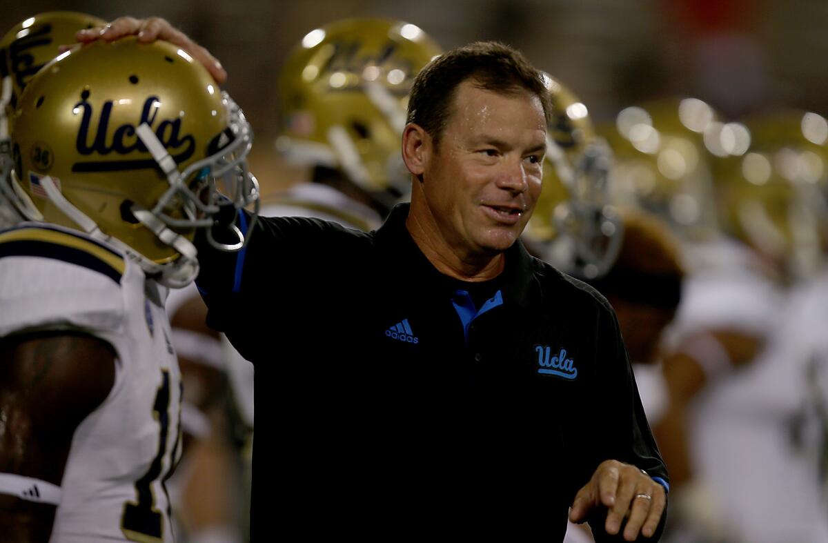 UCLA Coach Jim Mora watches the Bruins warm up before a game against Arizona State in Tempe, Ariz., on Sept. 25.