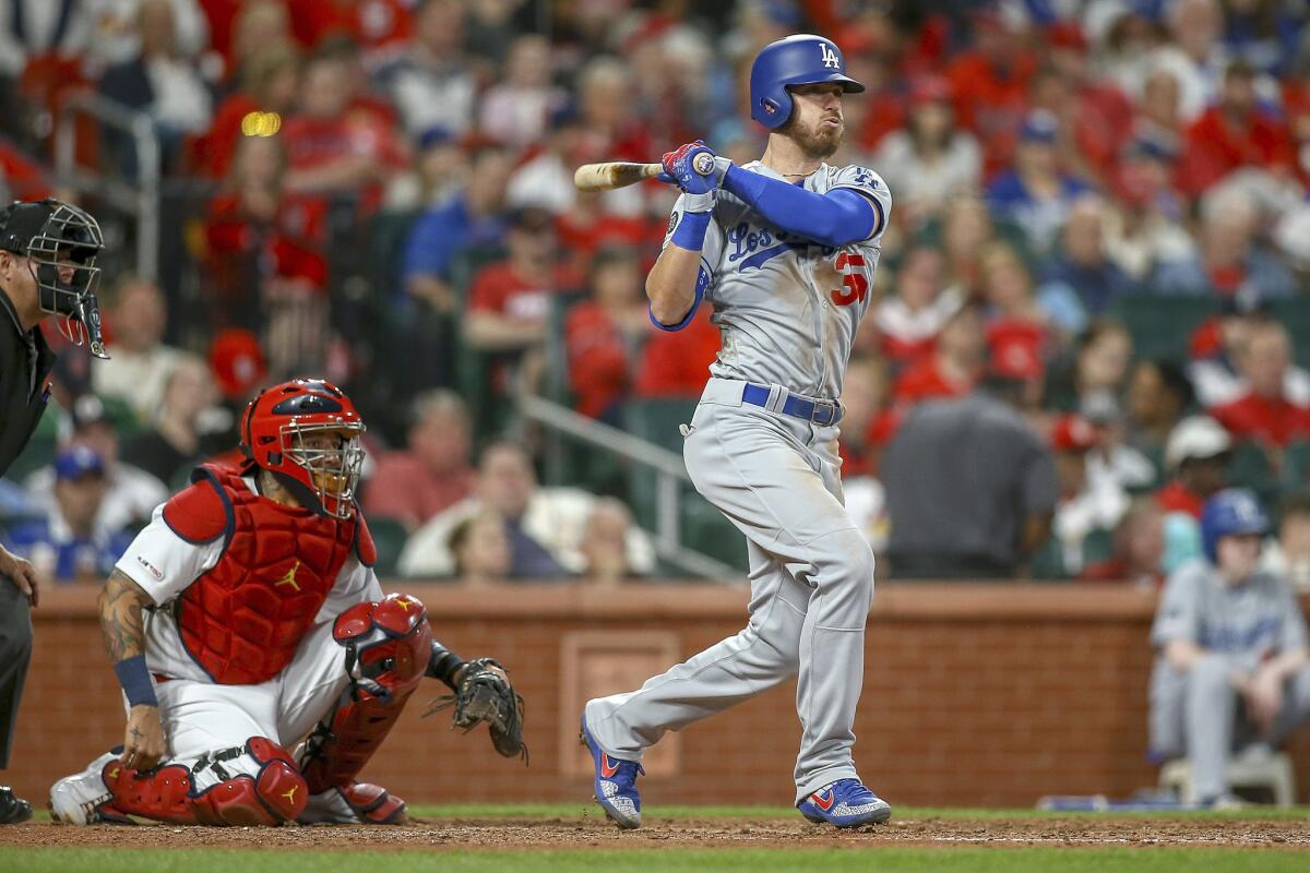 Cody Bellinger of the Dodgers tracks his fifth-inning double against the St. Louis Cardinals as catcher Yadier Molina looks on.