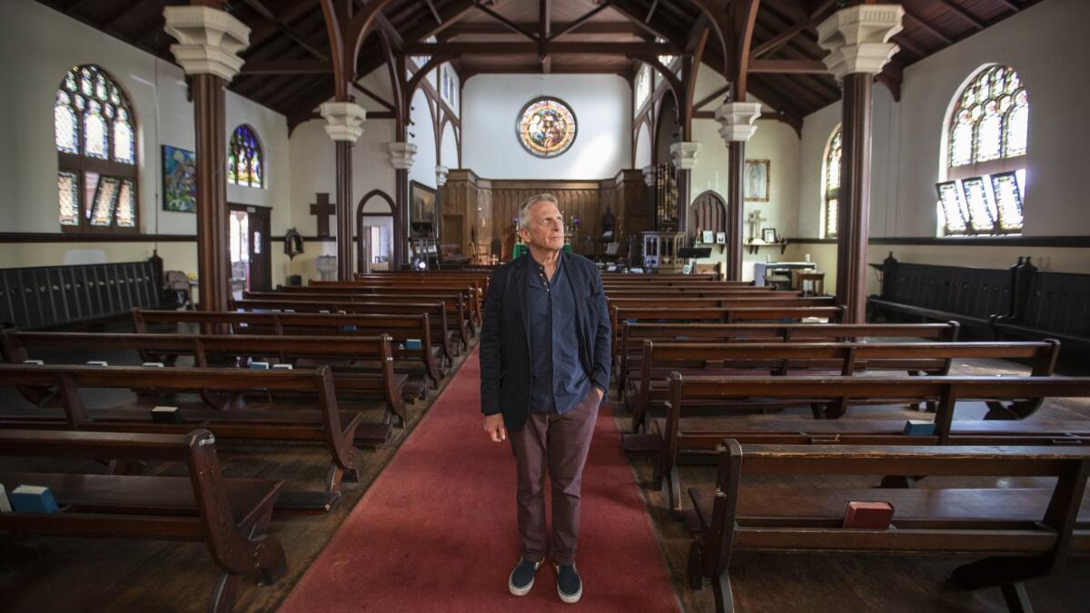 Father Tom Carey stands inside The Church of the Epiphany in Lincoln Heights, which was built in 1913.