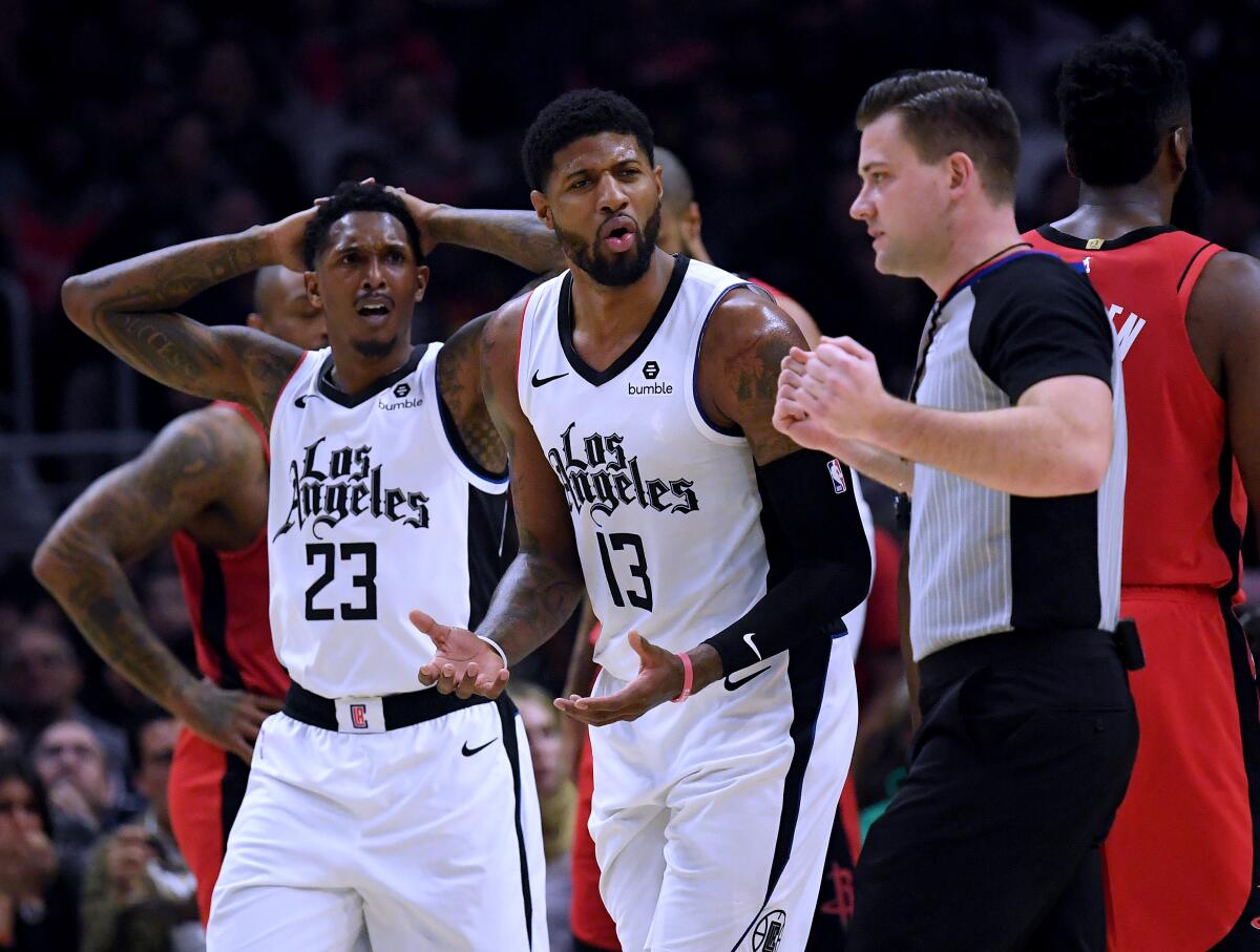 Clippers forward Paul George (13) and guard Lou Williams (23) react to a foul call during a loss to the Rockets on Dec. 19, 2019, at Staples Center.